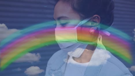 arco iris y cielo azul contra la mujer que lleva la máscara de la cara tos