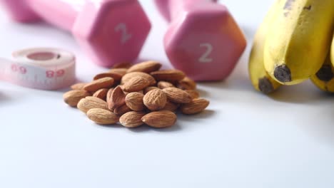 estilo de vida saludable con almendras, plátanos y pesas