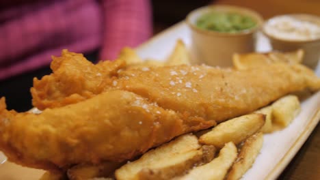 Battered-cod-and-chips-in-chip-shop,-England,-UK