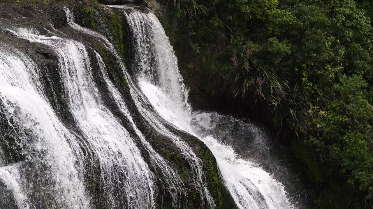 cascada cascada salpicando rocas y plantas de la densa jungla en nueva zelanda - waihi falls,nz