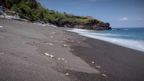 plastic garbage scattered on sandy shore at the beach in bali, indonesia