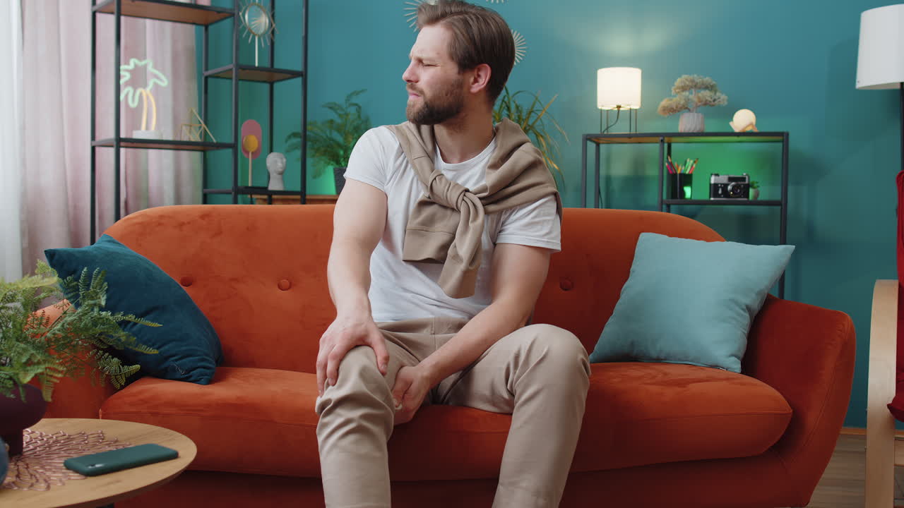 Young caucasian man suffer from painful severe knee joint ache leg muscles illness cramps rheumatism