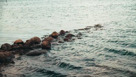 wet rocks laying in the riverbank on a windy, cloudy afternoon