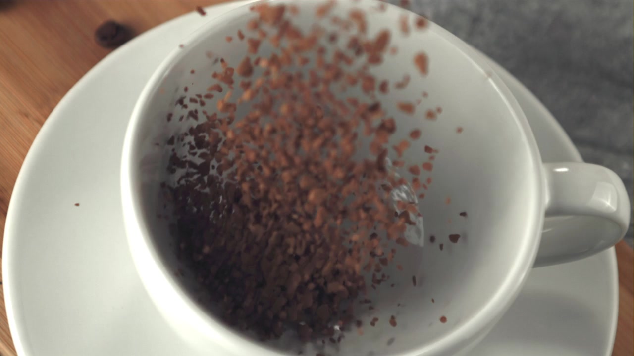 Granuli di Caffè Istantaneo che Cadono in una Tazza Bianca al Rallentatore