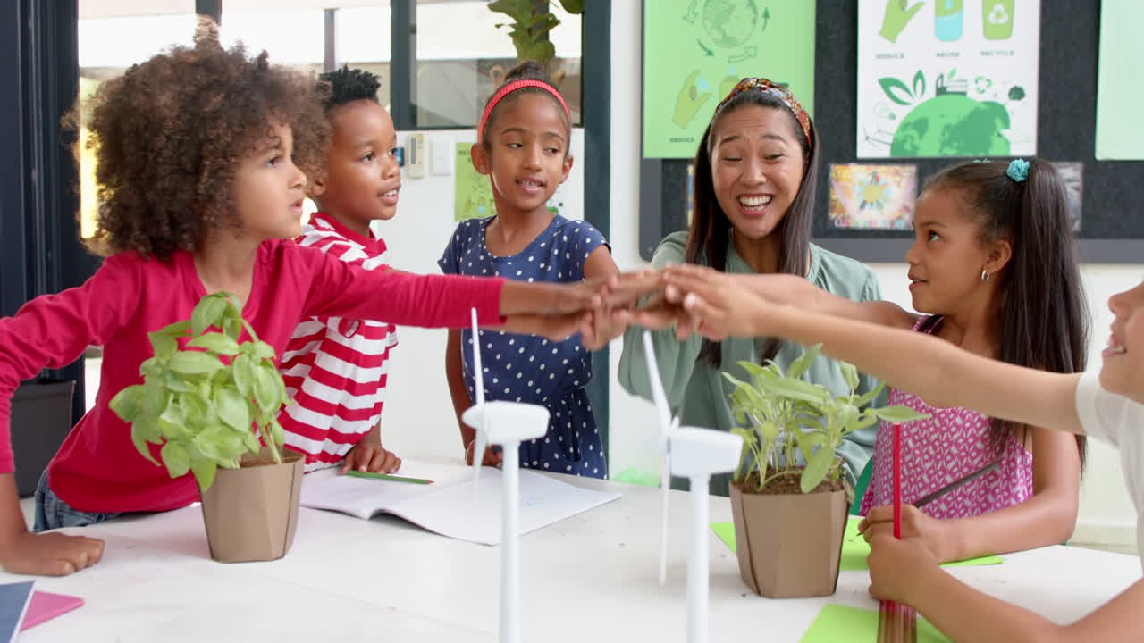 In school, teacher and children collaborating on environmental project with plants
