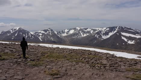 scotland mountains covered in snow with person walking drone shot