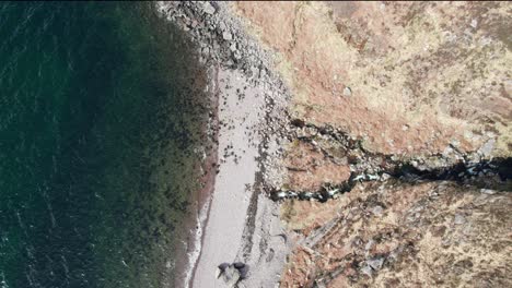 an aerial shot of a rocky beach in scotland