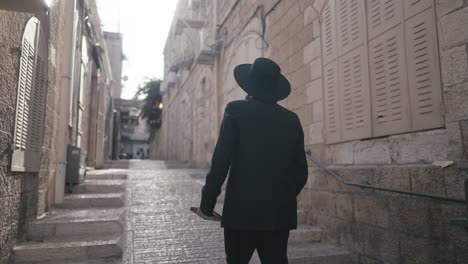 a man in traditional attire stands confidently against a stone wall, holding a book