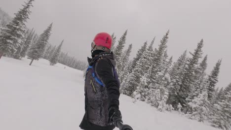 Snowboarder-Femenina-Cabalgando-A-Través-De-Polvo-Fresco-En-La-Estación-De-Esquí-De-Colorado,-De-Mano