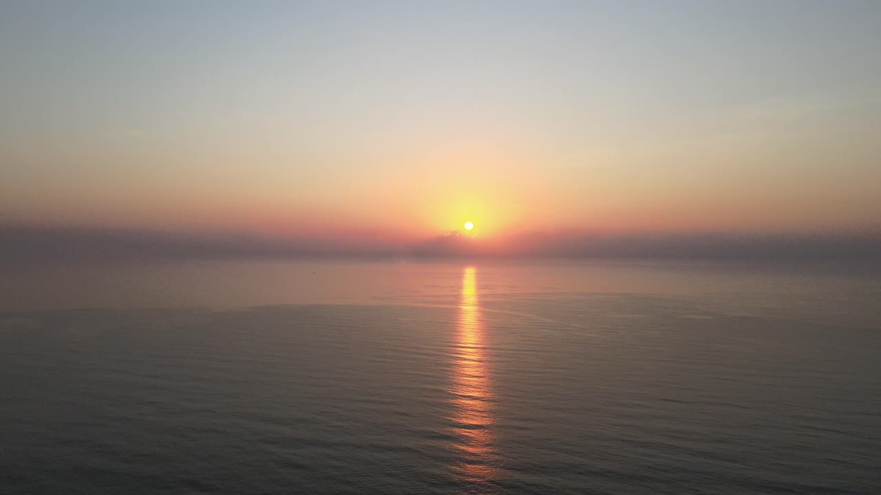Aerial Drone Shot Over the Gulf of Thailand with a Beautiful Sunrise with Orange Glowing Reflection on the Water.