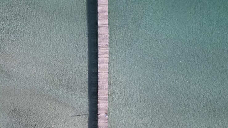 Straight Down view of Wooden Pier Going into Turquoise Blue Sea Water in Mallorca