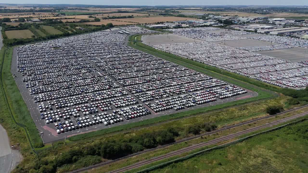 Cinematic aerial drone view of car rows at Grimsby import and export terminal with logistics and business facilities England UK