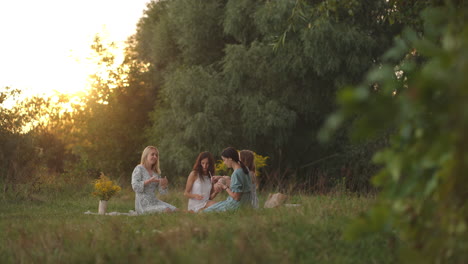 Mujeres-Jóvenes-Y-Atractivas-En-áreas-Abiertas-De-La-Naturaleza-Se-Dedican-A-Modelar-Con-Arcilla,-Dan-Forma-A-Los-Productos,-Se-Comunican,-Comparten-Impresiones,-Ríen,-Se-Dan-Consejos-Y-Se-Recomiendan-Entre-Sí.