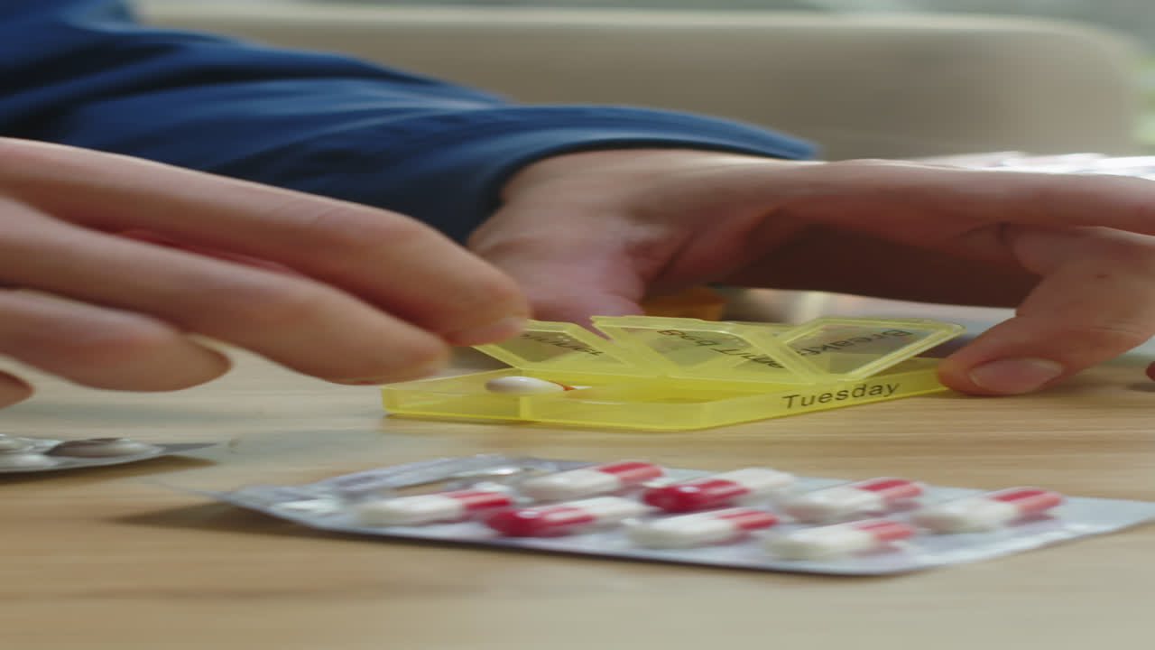 Unrecognizable Man Placing Supplements in Pill Box