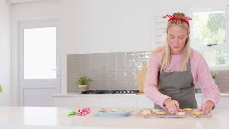 baking christmas cookies, woman decorating at home in festive headband, copy space