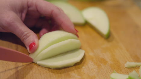 Closeup-of-a-sliced-apple-being-sliced-into-smaller-pieces-in-slow-motion