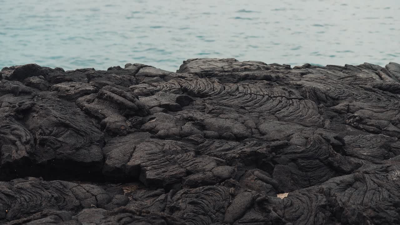 Beautiful molten volcanic rock hardened next to ocean in Hawaii (4k60p)