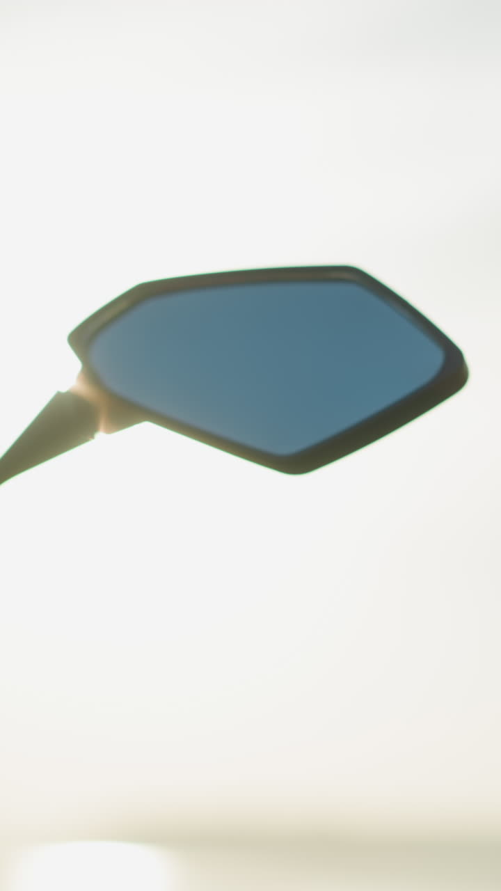 primer plano de alguien quitando un casco del espejo lateral de una bicicleta potente a la luz del sol brillante