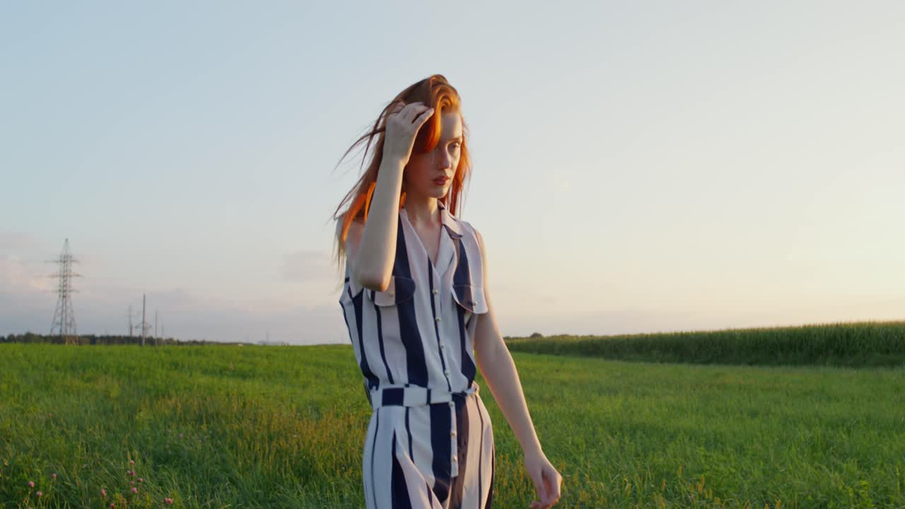 에서 해가 지는 동안 줄무 옷을 입은 여자