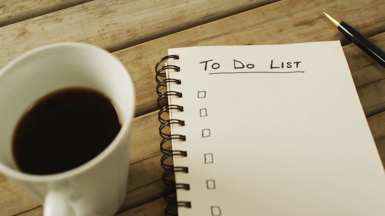 vídeo de cuaderno con lista de tareas y espacio para copiar, café y bolígrafo en superficie de madera