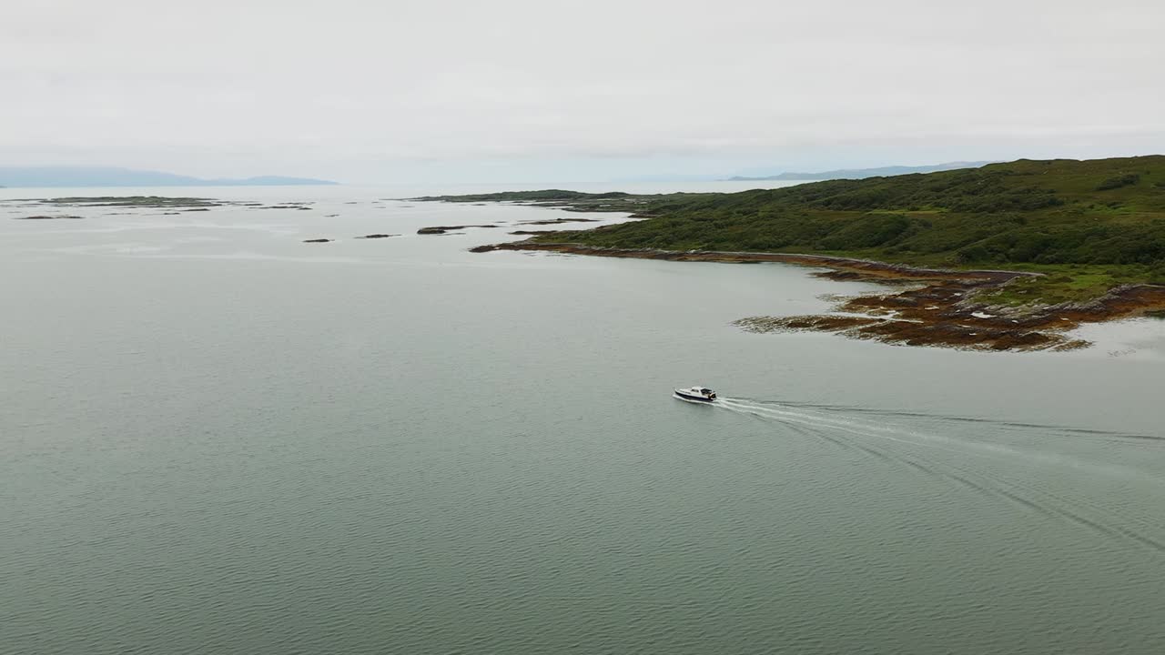 4K Aerial pan around boat leaving Arisaig harbour on Scottish West Coast