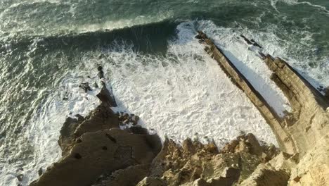 Tiro-Aéreo-Descendido-Sobre-El-Acantilado-Y-Las-Olas,-Sesimbra