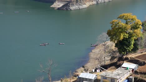 Ein-Blick-Aus-Der-Vogelperspektive-Auf-Einige-Kleine-Paddelboote-Auf-Dem-Kulekhani-See-In-Nepal,-Die-Touristen-Auf-Eine-Tour-über-Den-See-Mitnehmen