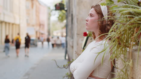 young woman walks down a city street in europe