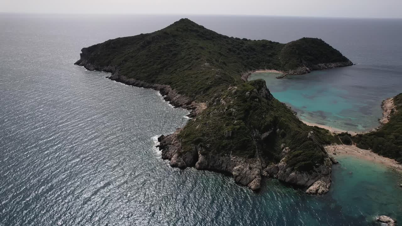 푸른 물과 하얀 해변으로 둘러싸인 녹색 섬의 시계 방향 회전 샷