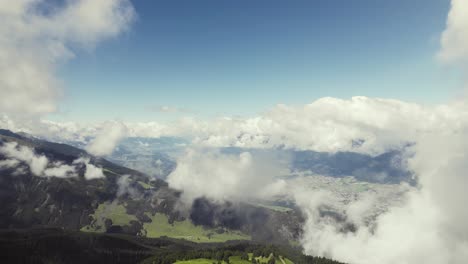 Aerial-drone-shot-of-a-grass-covered-mountain-top-flying-through-clouds