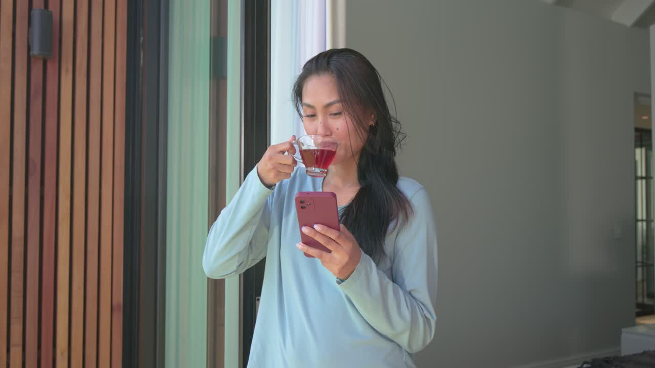 เสียงปลุกดัง หญิงเอเชียวัยกลางคนในชุดลำลองเดินไปที่ดาดฟ้า จิบชา และไถมือถือ