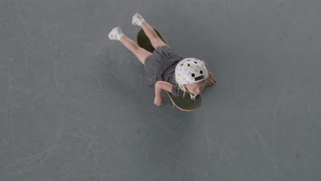 niño acostado en la patineta y moviéndolo