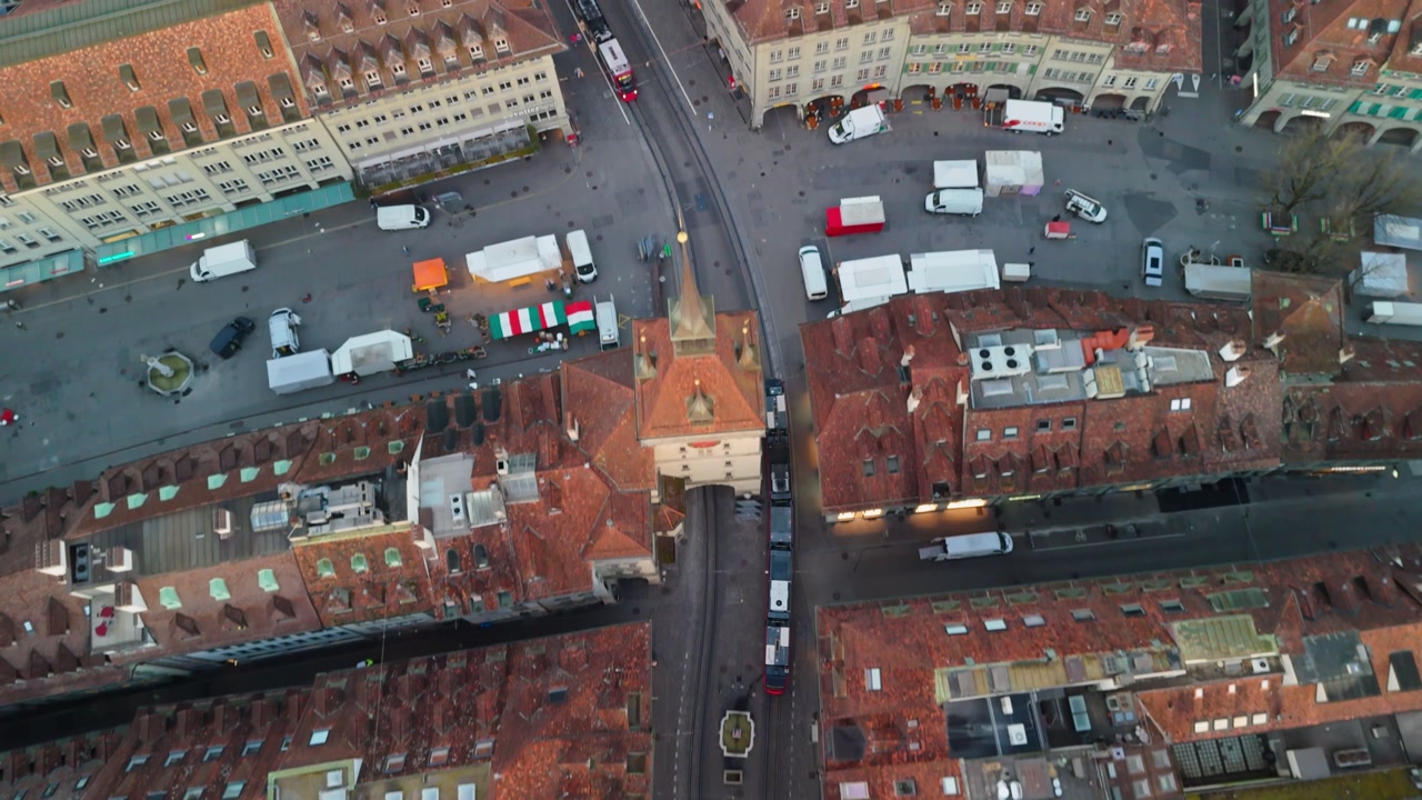 Droneshot following a tram through the streets of bern oldcity during carnevalmorning