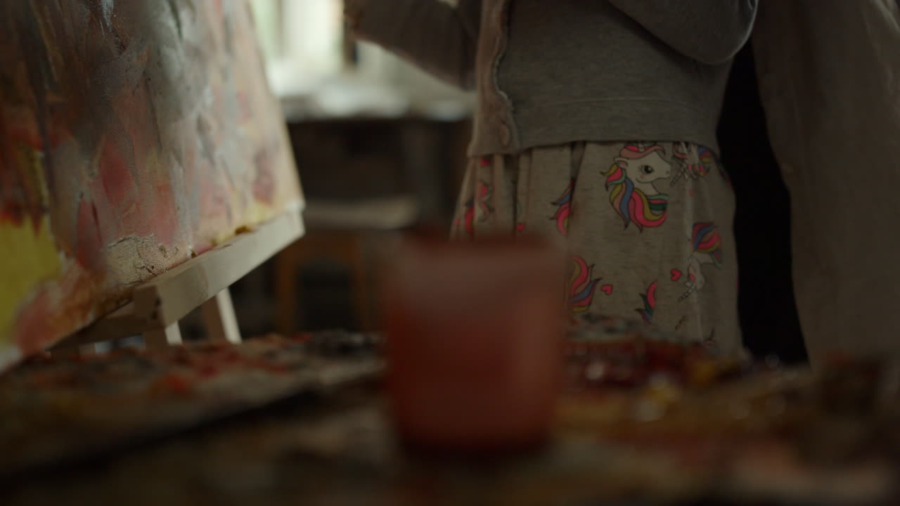 예술 스튜디오에서 창조적인 가족 그림. 사람들 손은 실내에서 기름 페인트를 혼합합니다.