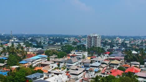 aerial view of kochi, a city in india , dwelling houses consisting of terraced houses , tanks placed above houses for drinking water supply , a skyline of a growing city and a mobile tower