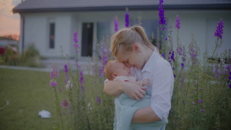 woman hugging infant boy in flower garden