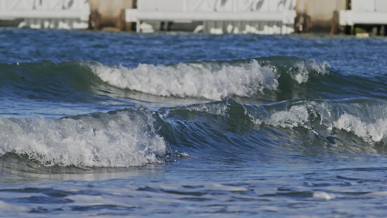 A gentle ocean wave rolling towards the shore near the Oosterschelde storm surge barrier, Zeeland, super slow motion