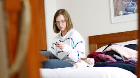 Frau-Benutzt-Digitales-Tablet-Und-Mobiltelefon-Im-Schlafzimmer