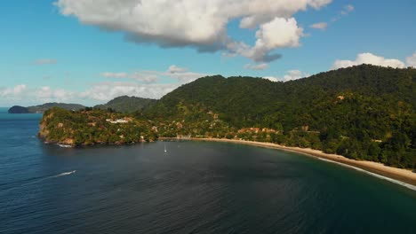 Toma-Aérea-De-Una-Larga-Playa-De-Arena-Con-Montañas-En-La-Espalda