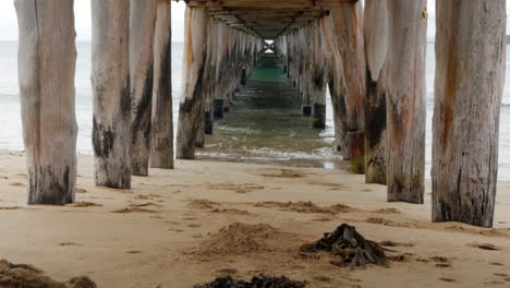 calm view underneath an old wooden pier or jetty