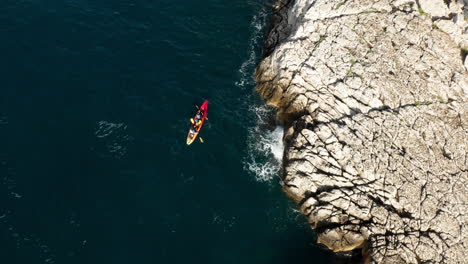 tourists kayaking beside the stony seaside near pula istria, croatia in europe during a sunny day