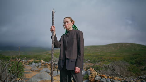 contemplative woman travel mountains on cloudy day. fashion girl posing rocky