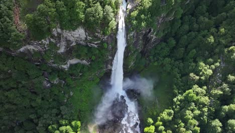 Aerial-of-stunning-waterfall-cascading-through-lush-forest-in-Maggiatal-Vallemaggia,-Ticino,-Switzerland