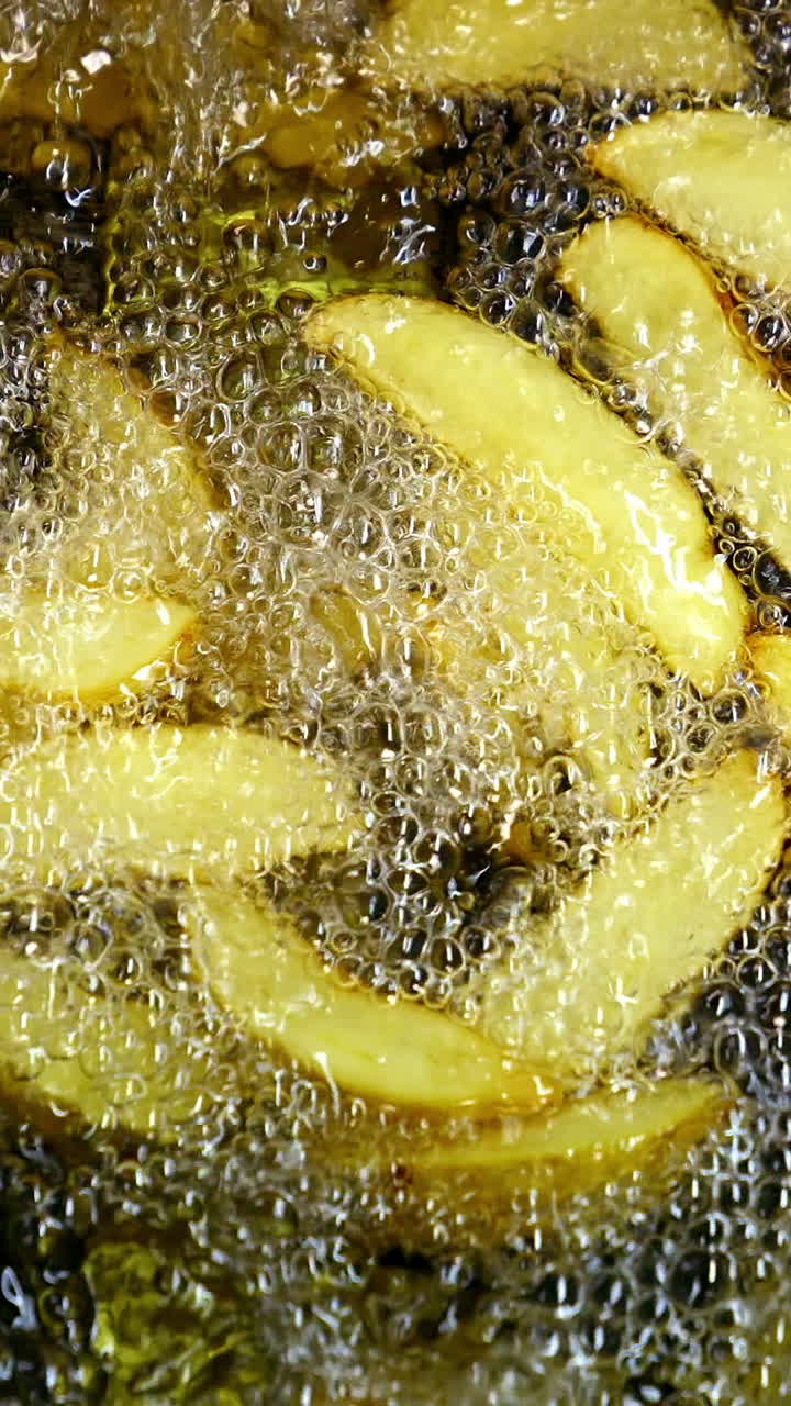 Golden potato in hot oil. French fries in the deep fryer are fried. Cooking crispy fries. Close-up. Vertical video