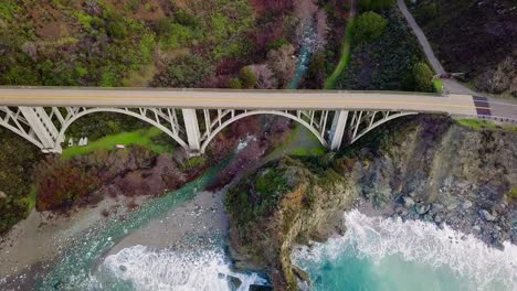 overhead aerial view of bixby creek bridge and crashing ocean waves in big sur on state route 1 in california