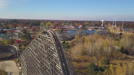 aerial of rollercoasters and nature in sunlight at amusement park