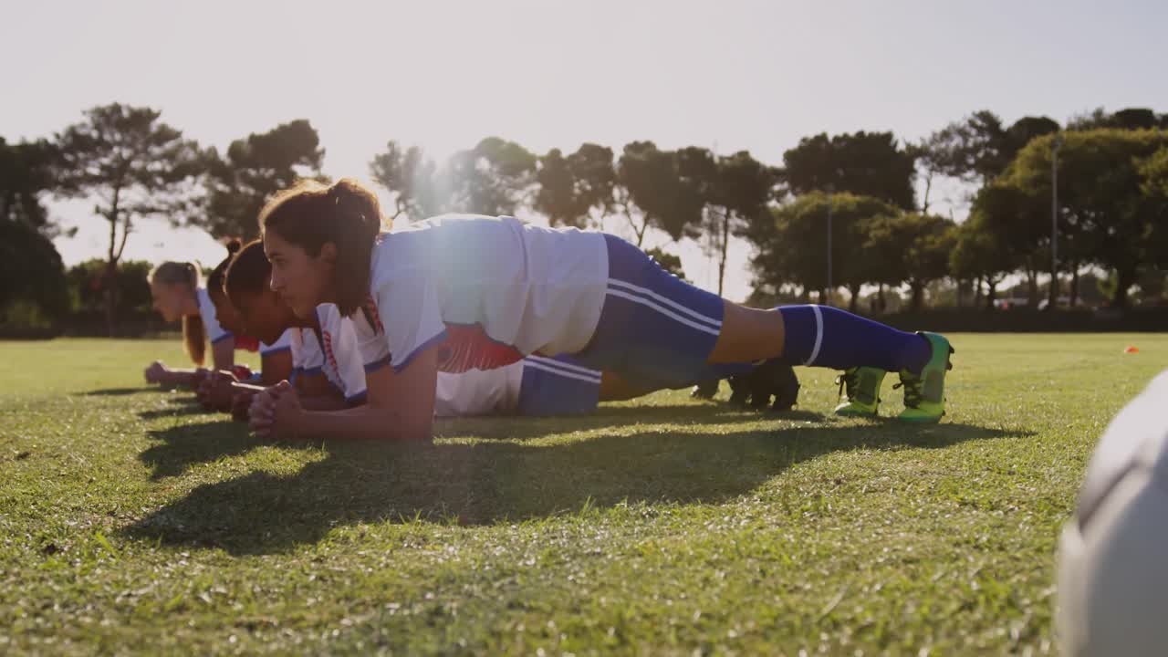 jugadoras de fútbol que hacen planking en el campo de fútbol. 4k