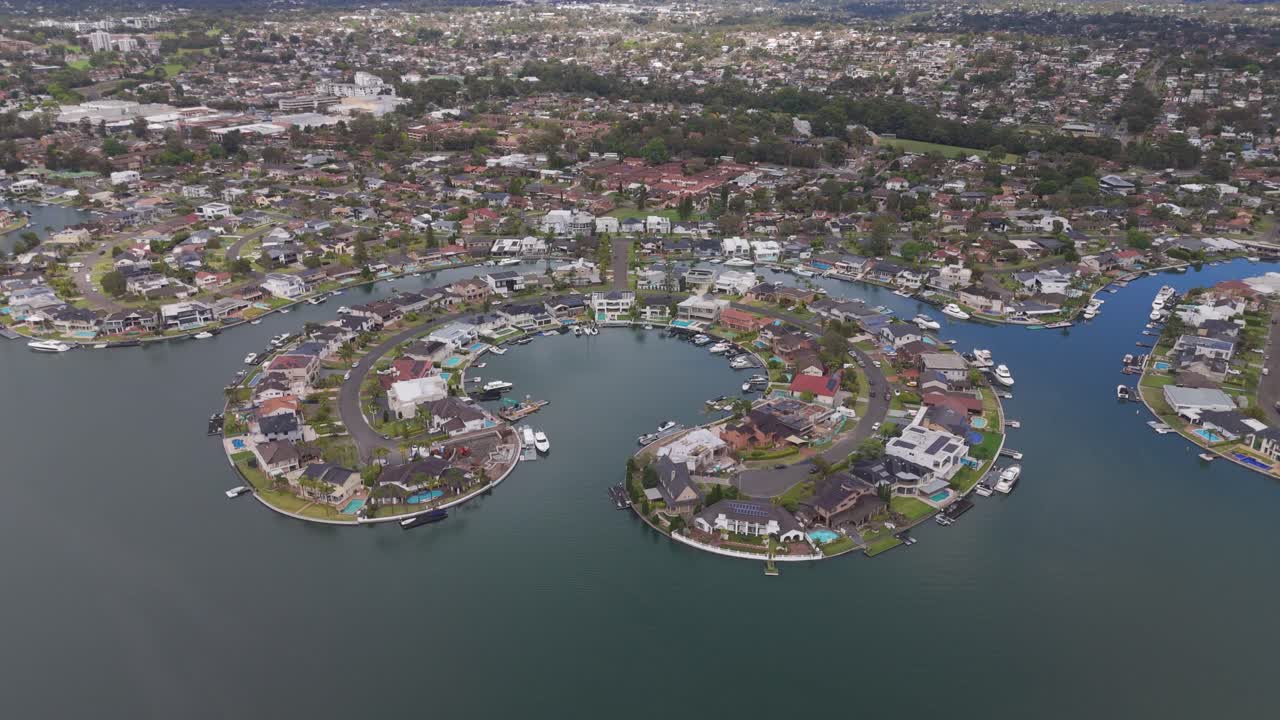 Stunning aerial orbit of luxury waterfront residences on James Cook Island in Sylvania Waters, Sydney, NSW, highlighting exquisite homes and tranquil coastal views.