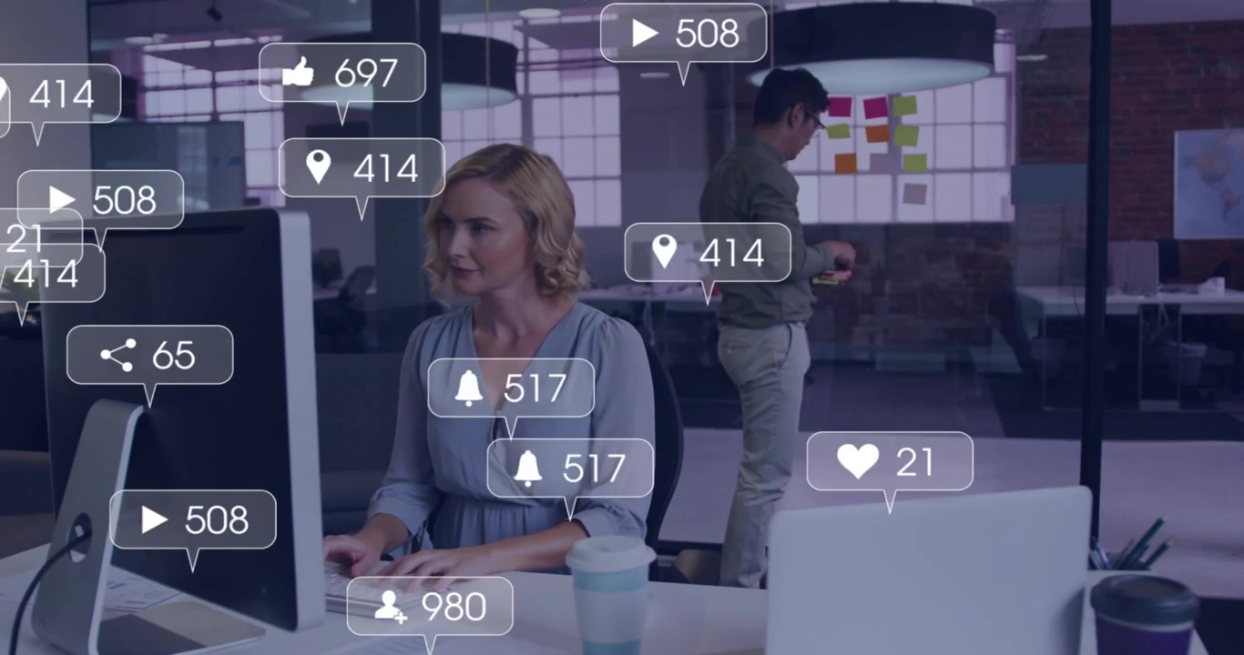 Woman typing on desktop initiating floating social stats and man adding sticky notes in marketing
