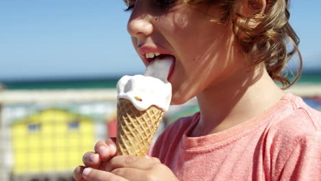 niño comiendo helado en la playa